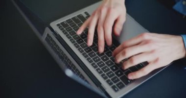 Şirket ofisinde çalışırken dizüstü bilgisayarda klavye kullanan genç girişimcinin elleri
