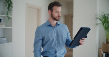 Sakallı, genç ve yakışıklı işadamının dijital tablet üzerinden video kaset stratejisini tartışırken şirket çalışma alanında durduğu kareler.