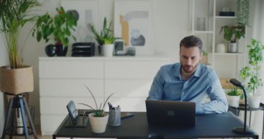 Güvenilir genç girişimci şirket işyerinde çalışırken bilgisayarla video görüşmesi stratejisini tartışıyor