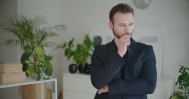 Genç sakallı profesyonel erkek kalem beyin fırtınası stratejisi kurum işyerindeki siyah iş kıyafetleri içinde dururken
