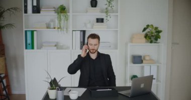 Yakışıklı genç girişimcinin masada oturup ofiste iyi haberleri dinlerken telefonuna cevap verişini çekiyoruz.