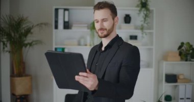 Sakallı, genç ve yakışıklı işadamının dijital tablet vasıtasıyla strateji tartışması çekimleri.