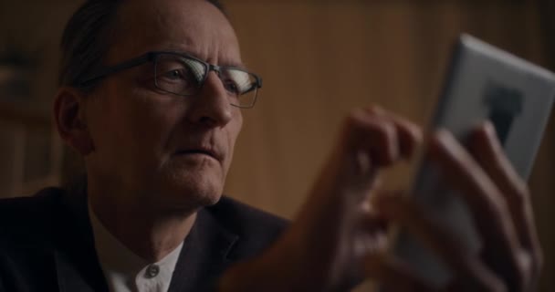 Seriöser Geschäftsmann Mit Brille Liest Spätabends Arbeitsplatz Auf Digitalem Tablet — Stockvideo