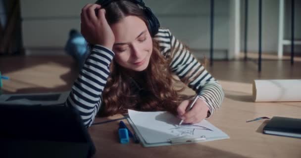 Mulher Bonita Feliz Deitada Chão Enquanto Desenha Escuta Música Sala — Vídeo de Stock