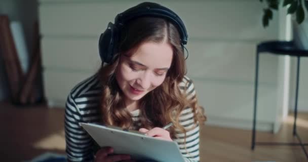 Vonzó Fiatal Barna Lány Élvezi Zenét Fejhallgatón Keresztül Miközben Rajzol — Stock videók