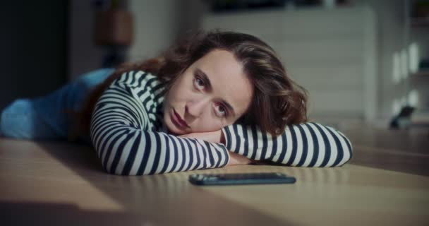 ภาพเคล อนไหวช าของหญ งสาวท เหงาและเศร านอนอย บนพ นโดยโทรศ อในห องน — วีดีโอสต็อก