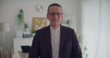 Ağır çekimde, iş yerinde kolları çapraz duran ve spor ceket giyen kendinden emin erkek girişimcinin portresi.