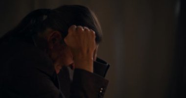 Ofiste geç saatlere kadar otururken bağıran gergin üst düzey yöneticinin yan görüntüsü