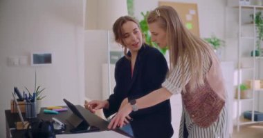 Genç bayan girişimciler dijital tablet üzerinde tartışırken kurumsal çalışma ortamında beyin fırtınası stratejisi oluşturuyorlar.
