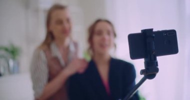 Evde Monopod 'da akıllı telefondan bir araya gelen genç kadın nüfuzlu kişilerin yavaş çekim görüntüleri.