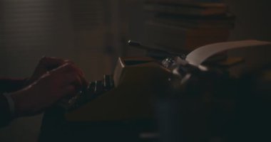 Üst düzey bir adam, klasik daktiloyla daktilo yazıyor. Evinin sessizliğinde, gece gökyüzünün altında derin bir tefekkür içinde kitabını yazıyor.