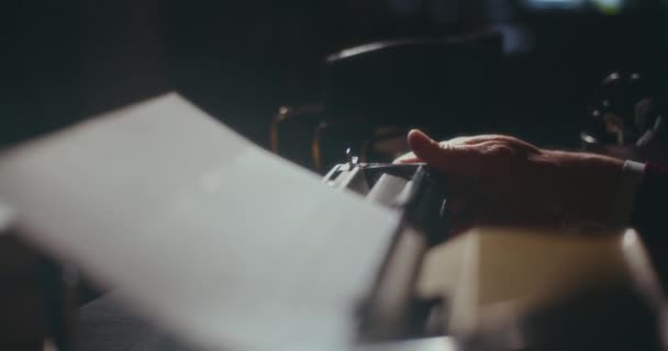 老人一边在老式打字机上打字 一边沉思地在家里安静的地方写着他的书 在夜空中沉思着 — 图库视频影像