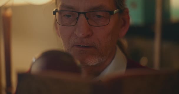 Ηλικιωμένος Κύριος Βυθισμένος Στη Νυχτερινή Ανάγνωση Γοητευμένος Από Ένα Βιβλίο — Αρχείο Βίντεο
