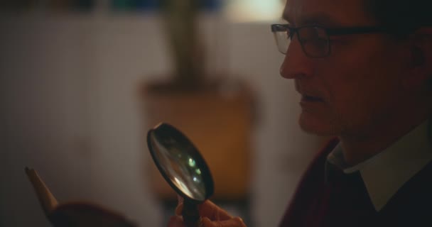 Yaşlı Bir Beyefendi Gece Vakti Kitap Okumaya Dalmış Bir Büyüteçle — Stok video