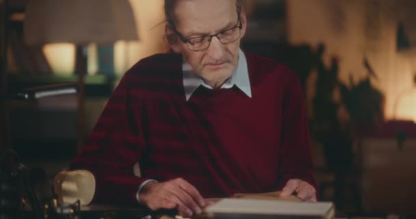Ηλικιωμένος Κύριος Βυθισμένος Στη Νυχτερινή Ανάγνωση Γοητευμένος Από Ένα Βιβλίο — Αρχείο Βίντεο