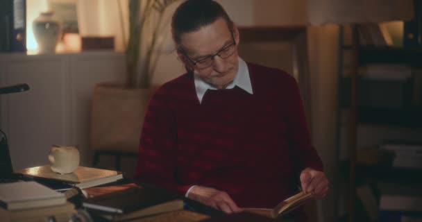 Elderly Gentleman Immersed Nighttime Reading Captivated Book Soft Dimmed Light — Stock Video