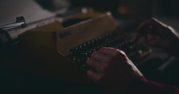老人一边在老式打字机上打字 一边沉思地在家里安静的地方写着他的书 在夜空中沉思着 — 图库视频影像