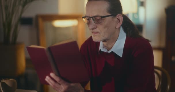 Äldre Gentleman Nedsänkt Nattläsning Fängslad Bok Mjukt Dimmat Ljus Bekvämligheten — Stockvideo