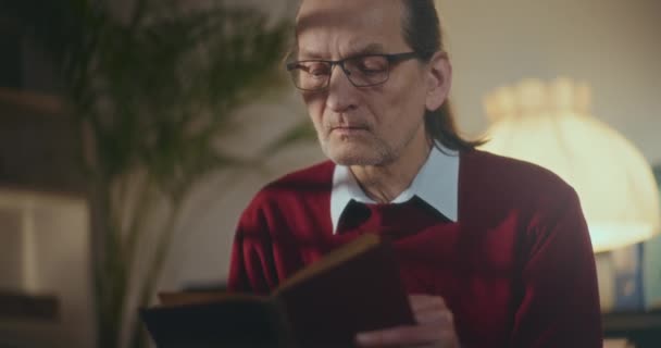 Elderly Gentleman Immersed Nighttime Reading Captivated Book Soft Dimmed Light — Stock Video