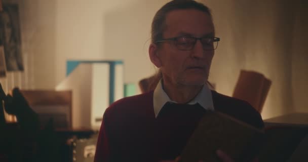 Äldre Gentleman Nedsänkt Nattläsning Fängslad Bok Mjukt Dimmat Ljus Bekvämligheten — Stockvideo