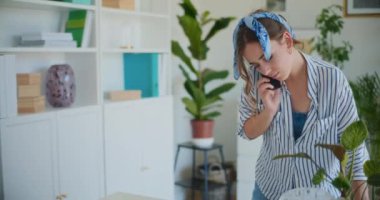 Görevleri iyi idare eden bir kadın, evini temizlerken ve düzenlerken bir telefon görüşmesi yapar ve birden fazla işi kolaylıkla yapabildiğini gösterir.