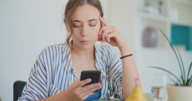 Kadın akıllı telefondan evden online alışveriş yapıyor.
