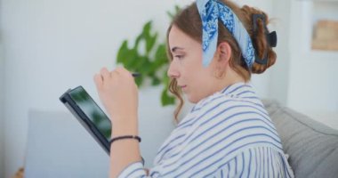 Çalışkan bir kız öğrenci aktif olarak çevrimiçi öğrenim faaliyetlerine katılıyor. Eğitimini oturma odasının rahatlığıyla zenginleştiriyor.