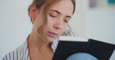Kendini notları okumaya ve not defterine yazmaya kaptırmış bir kadın.