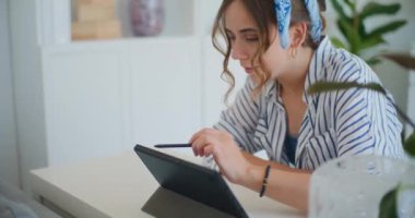 Bir kadının dijital tableti titizlikle ve dikkatle kullanırken ellerini yakalayan detaylı bir yakın çekim.