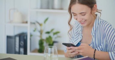 Olumlu kadın akıllı telefondan mutlu bir şekilde mesajlaşıyor ve alışveriş yapıyor.