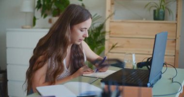 Kadın internetten öğreniyor, not alıyor.