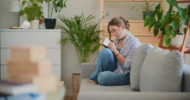 Kanepeye notlar yazarken ciddi bir kadın derin düşüncelere dalmış.