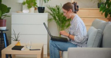 Nişanlı ve odaklanmış bir iş kadını, uzaktan çalışırken bilgisayarında bir video konferansı düzenliyor.