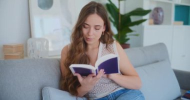 Kitap okumaya dalmış bir kadın, derin bir odak gösteriyor.