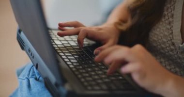 Dizüstü bilgisayarda yazıyorum. Kanepede oturan, vurulmuş bir kadın.