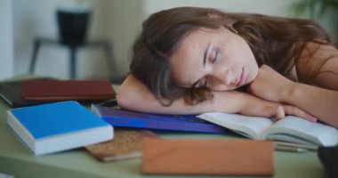 Kitapların üzerinde uyuyan bir kadın, sıkıcı bir kız öğrenci.