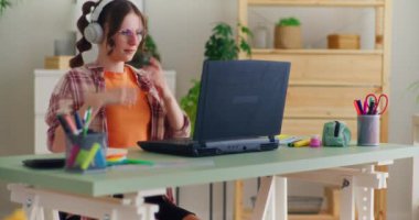 Genç öğrenci bilgisayarını çevrimiçi bir derse hazırlanmak için kuruyor, uzaktan öğrenmeyi kucaklıyor