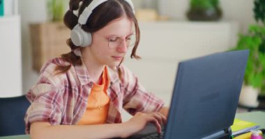 Yoğunlaşmış genç, ödevlerini yoğun bir şekilde bir dizüstü bilgisayarla yapıyor ve derslerine odaklanıyor.