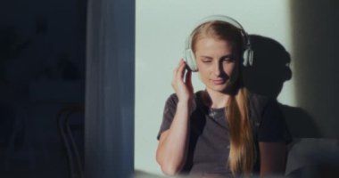 Bir kadın kulaklıkla müzik dinlemekten hoşlanır, gözle görülür şekilde mutlu ve tecrübeden memnun.
