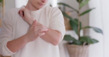 Bir eşekarısı tarafından sokulduktan sonra ağrı kesici jel süren kadın.