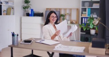 Mutlu bir iş kadını şirketin mali raporunu inceler ve sonuçlarından gurur duyar..