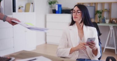 Kendine güvenen bir iş kadını bir çalışandan mali rapor alır ve şirket belgelerini gözden geçirir..