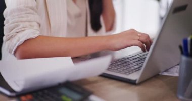 Ofiste çalışan meşgul bir iş kadını dizüstü bilgisayarda yazıyor ve e-postalara cevap veriyor..