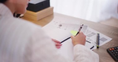 Ofiste çalışan bir kadın not defterine yazıyor..