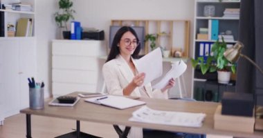 Mutlu bir iş kadını şirketin mali raporunu inceler ve sonuçlarından gurur duyar..