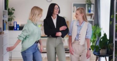 Mutlu iş kadınları yeni bir anlaşma yaptıktan sonra masaya yaslanırlar..