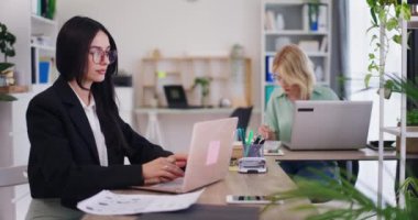 Ofiste dizüstü bilgisayarlarla çalışan kadın ofis çalışanları..