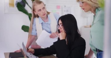 Kadın şirket çalışanları bir projede birlikte çalışıyorlar, belgeleri analiz ediyorlar ve beyin fırtınası yapıyorlar..