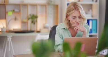 Dizüstü bilgisayarda çalışan düşünceli bir kadın..