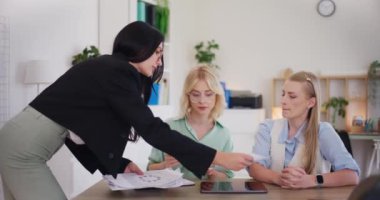 Bir takım lideri, ofisteki bir iş toplantısında çalışanlara görevler dağıtır..